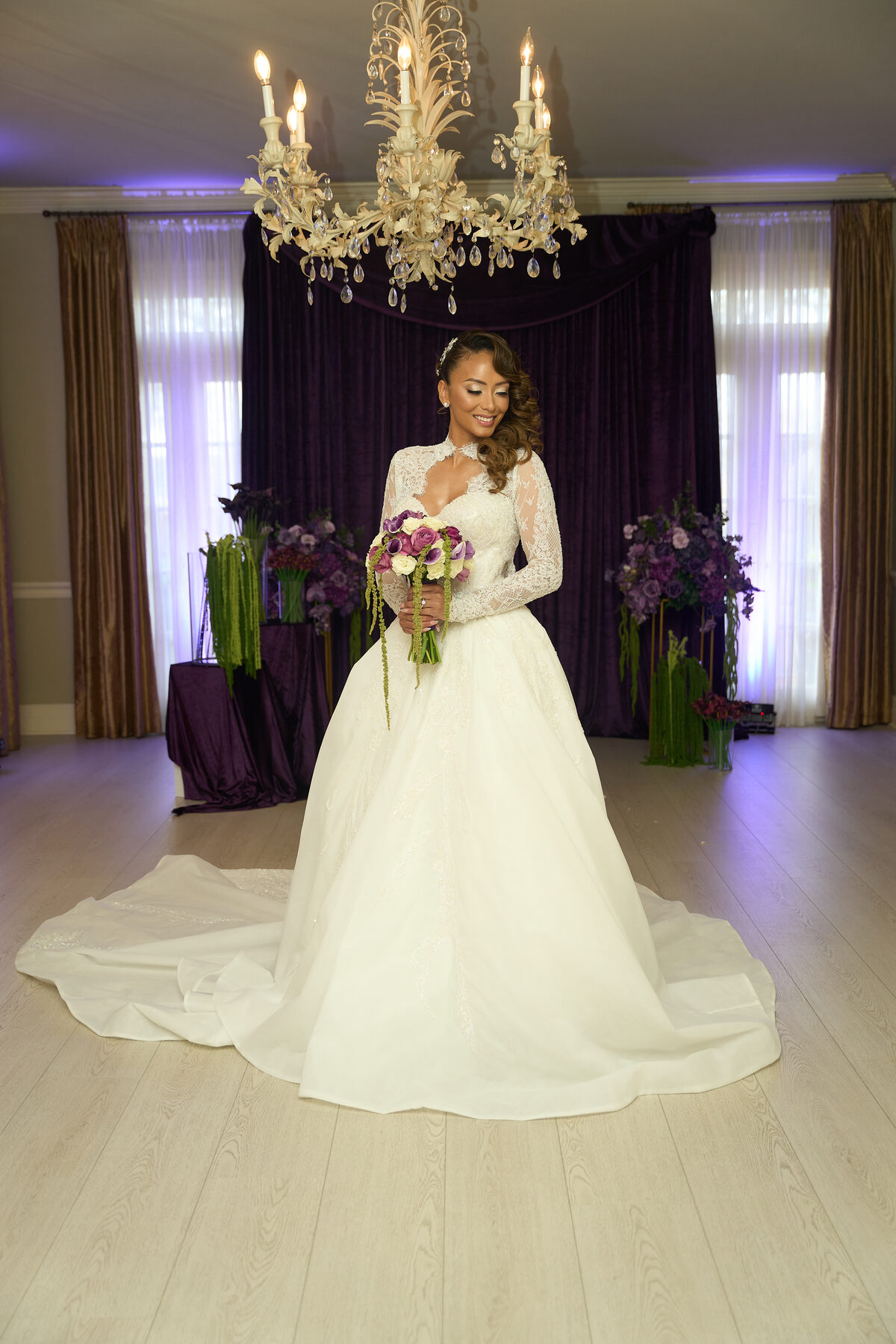 Full length bridal portrait in ballroom with ornate chandelier