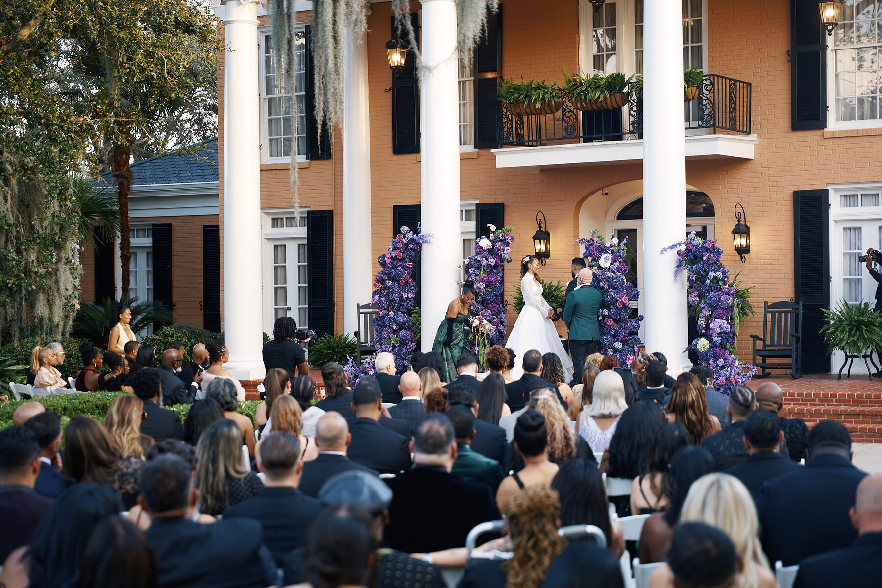 Wide shot of outdoor wedding ceremony at a historic mansion venue