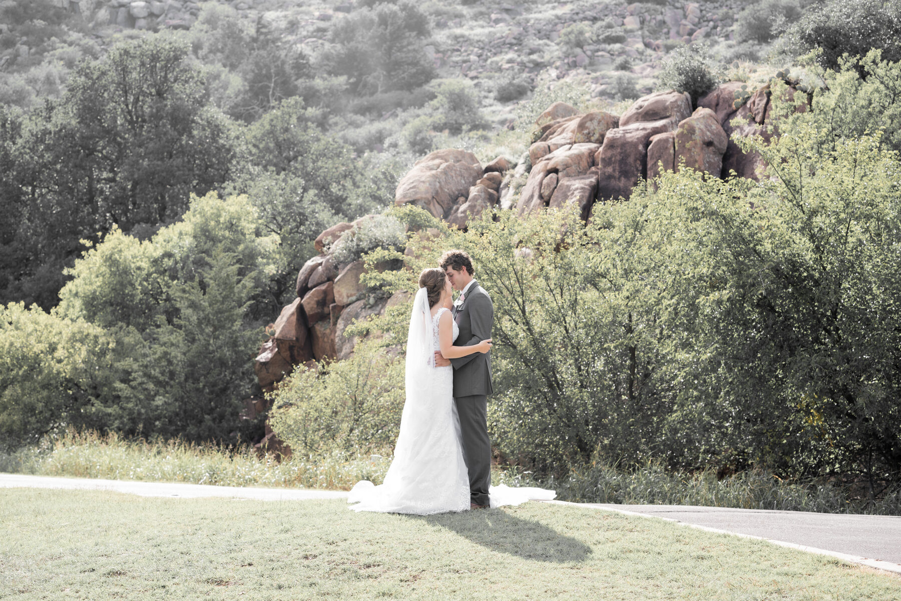 Bride and groom embracing in a scenic outdoor landscape