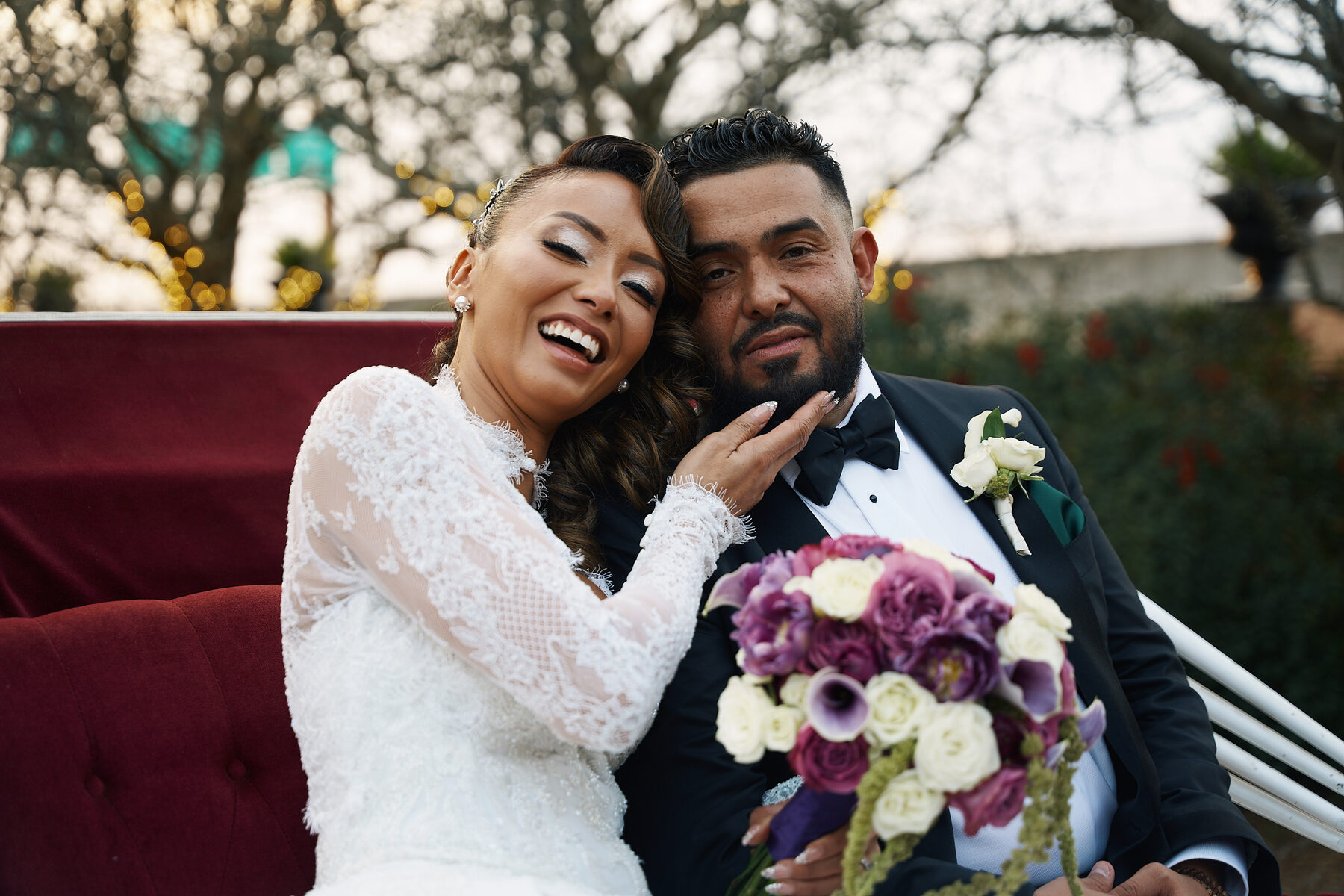 Bride and groom laughing together in a vintage carriage